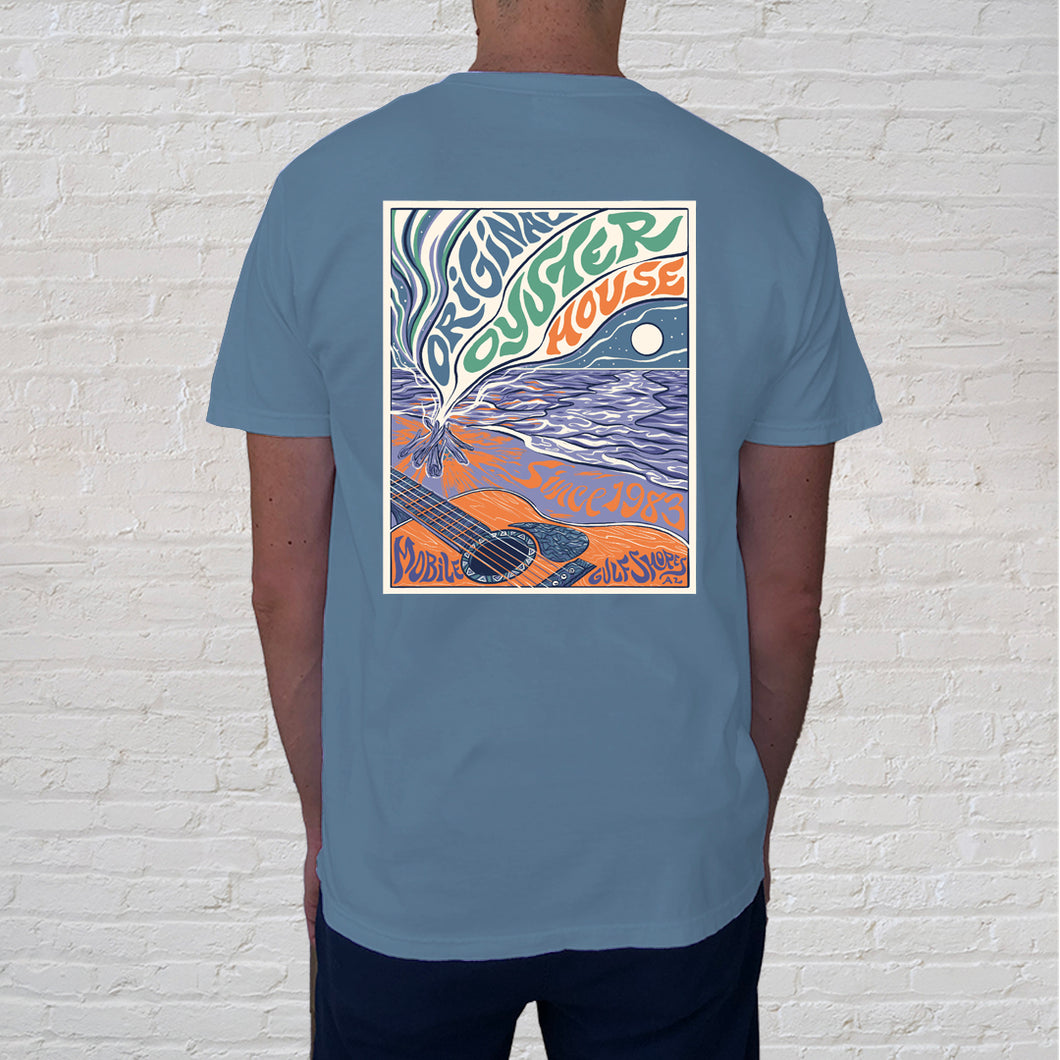 Back design of t-shirt | As the sun begins to set and twilight is near, the beach offers an unforgettable ambience. This is when beachcombers settle in, enjoy acoustical guitar playing, a campfire and sing alongs. The Beach Guitar limited edition, collectible t-shirt features a chic graphic illustration on the back and a front pocket design branded with the Original Oyster House.