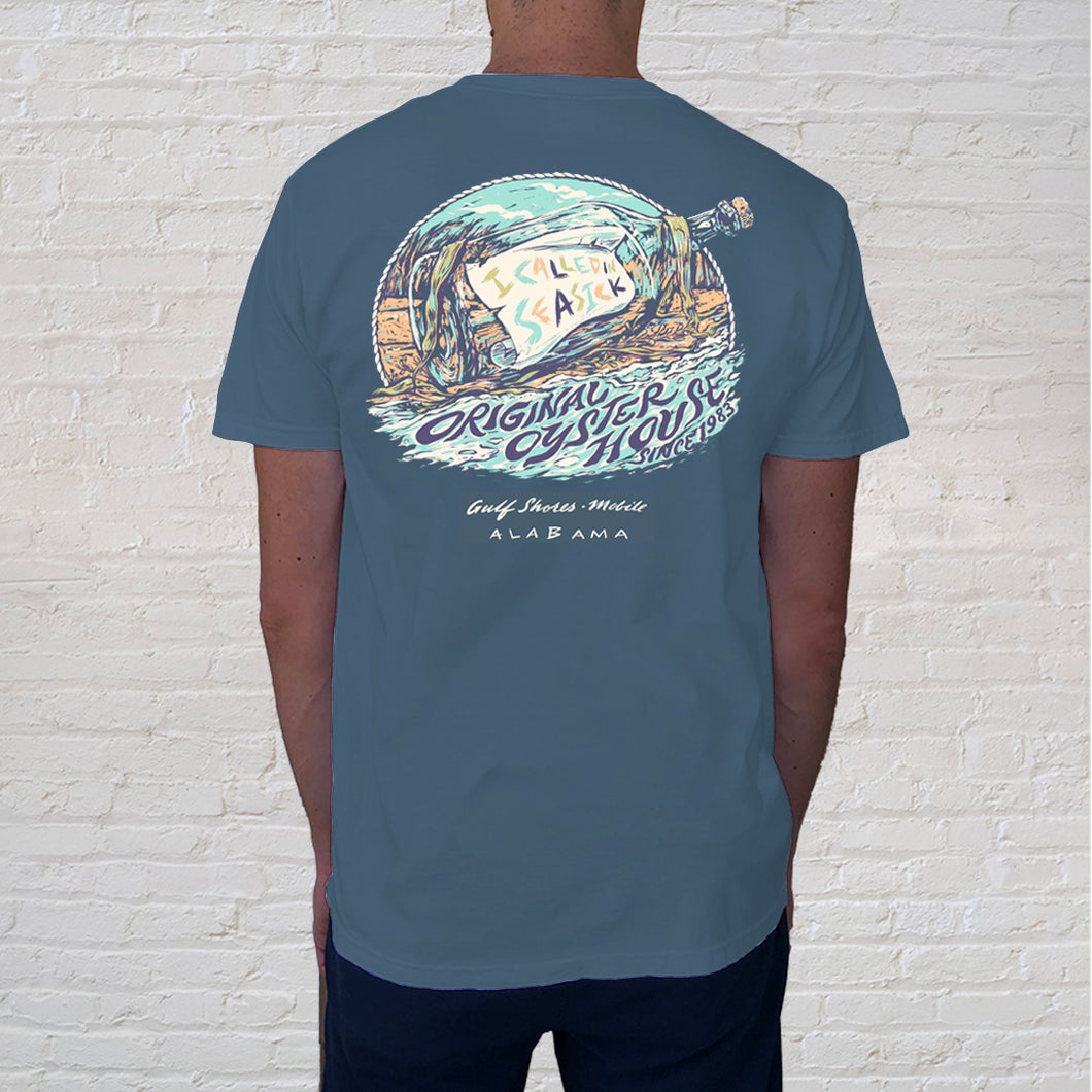 Back of denim t-shirt | This rustic but funky designed tee pokes fun at a message in a bottle. The calling in seasick graphic captures the movement and energy of Gulf waves while the coastal colors will call you back to the beach.